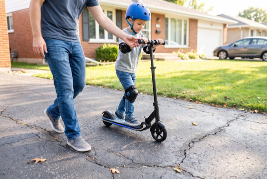 Young child in helmet and pads on a Novi M1 electric scooter with a parent alongside